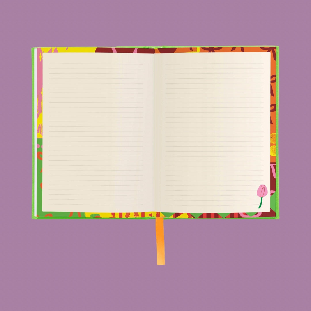 An open lined notebook with a colorful abstract patterned cover and an orange ribbon bookmark, centered on a solid purple background.