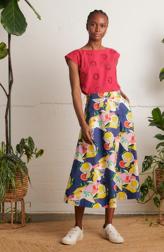 Model is wearing Emily & Fin Sandra Picnic Party Skirt paired with a coral coloured top and white sneakers