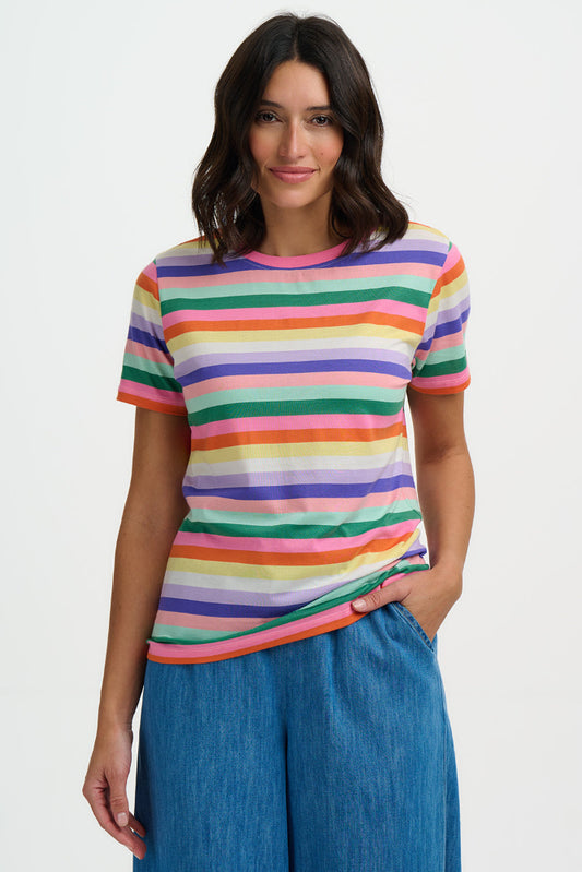 Woman wearing a colorful striped shirt and blue pants on a white background