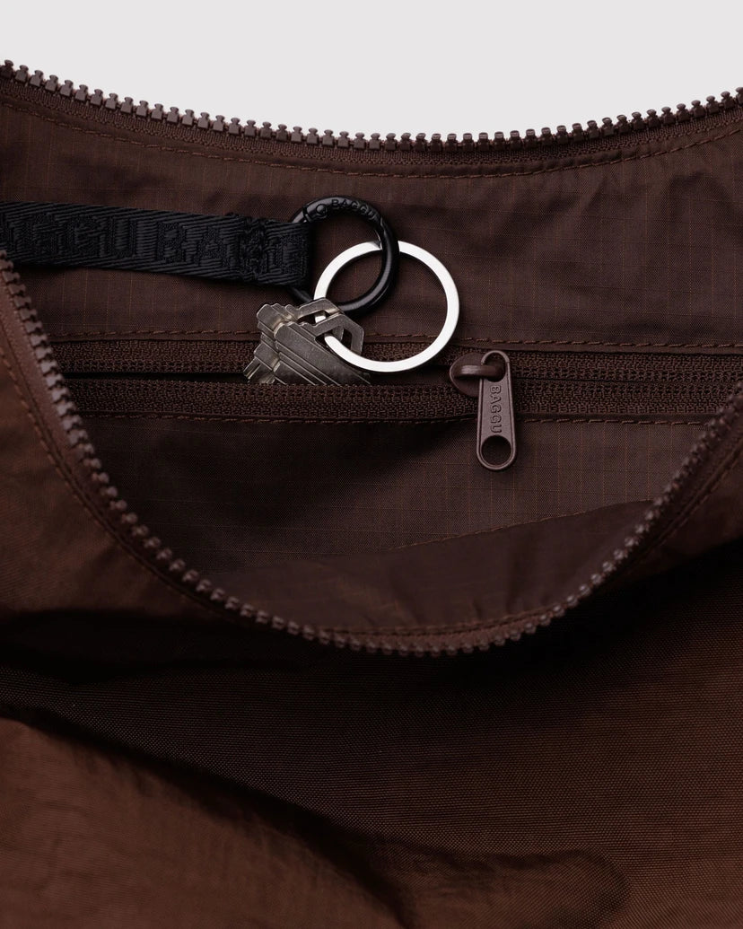 Close-up of the inside of a brown bag with a zipper and keychain attached.