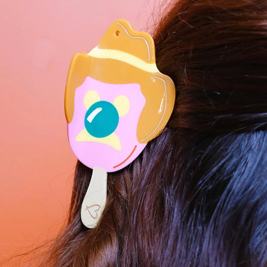 Hair claw shaped like Bubble O' Bill ice cream in dark straight hair.