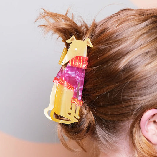 A hair claw shaped like a Greyhound wearing a knitted jumper in straight blond hair.