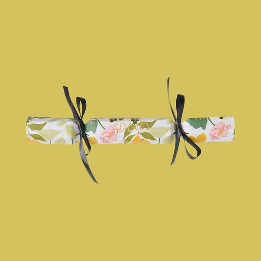 Packaging for Kip & Co Wander Velvet Eye Mask - Floral cracker with black ribbons on a yellow background