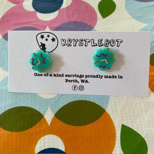 starburst shaped turquoise coloured earrings with multi coloured squiggles on a Krystlebot branded card