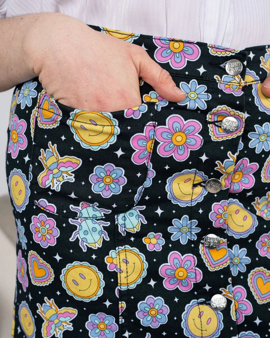 Close up of pocket details of Run and Fly Bee Happy Mini Skirt. Model has one hand inside the pocket.