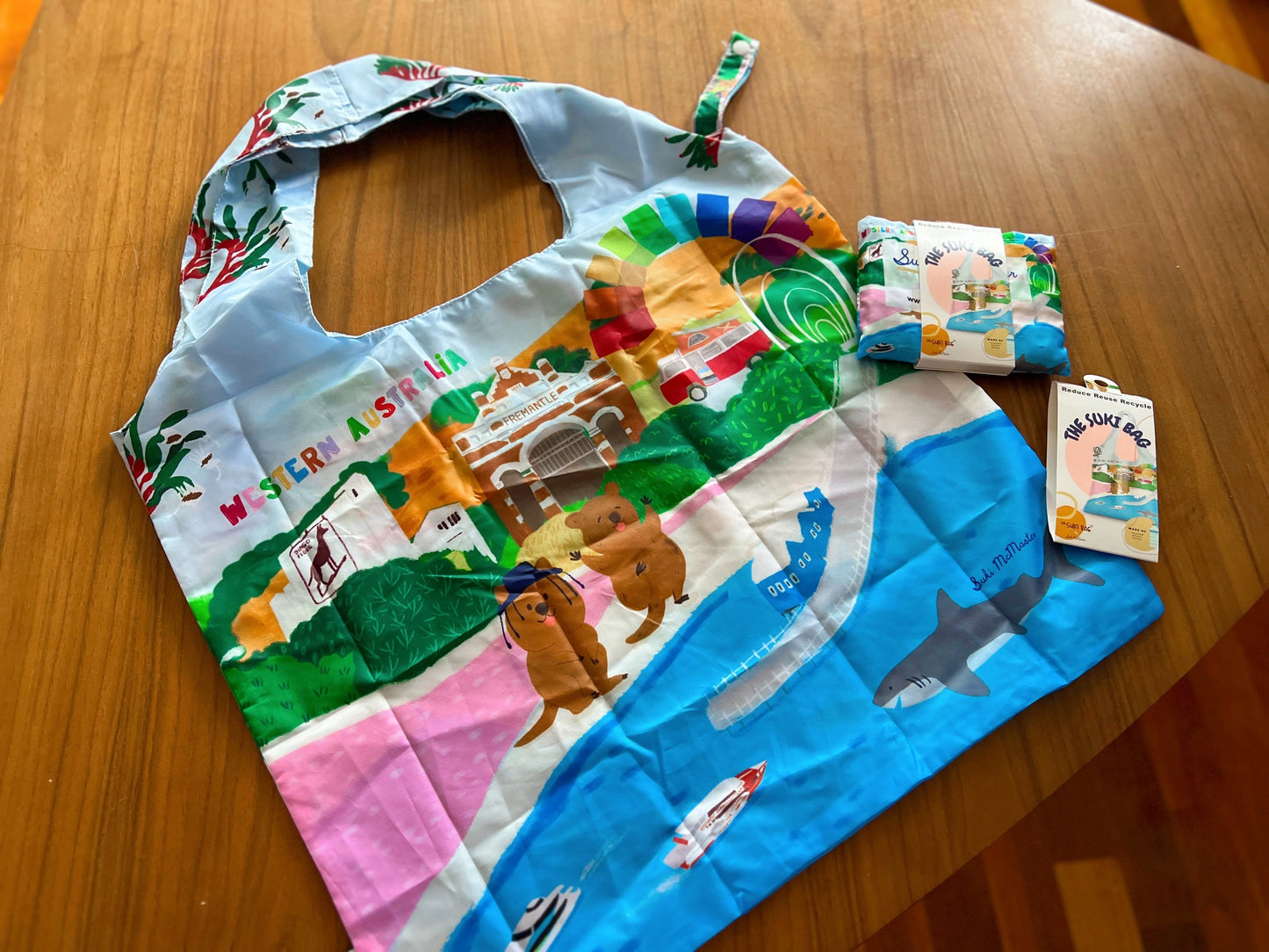 Colorful reusable bag and pouch on a wooden surface