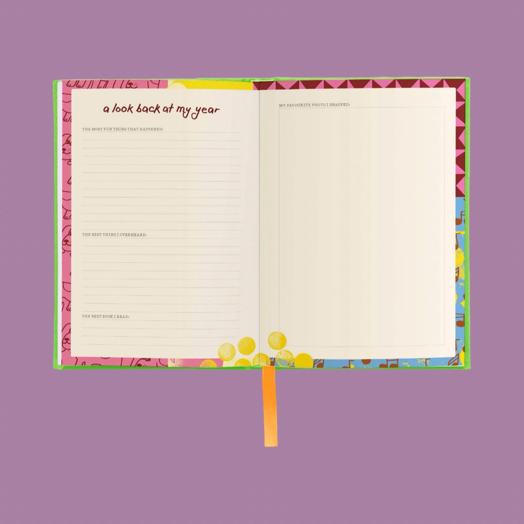 An open notebook or journal with lined and blank pages, featuring a colorful patterned cover and ribbon bookmark, shown on a solid purple background.
