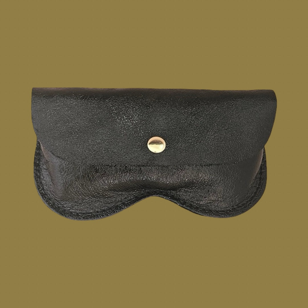 Black textured metallic leather glasses case with a gold-tone snap button, shown against a solid olive-brown background.