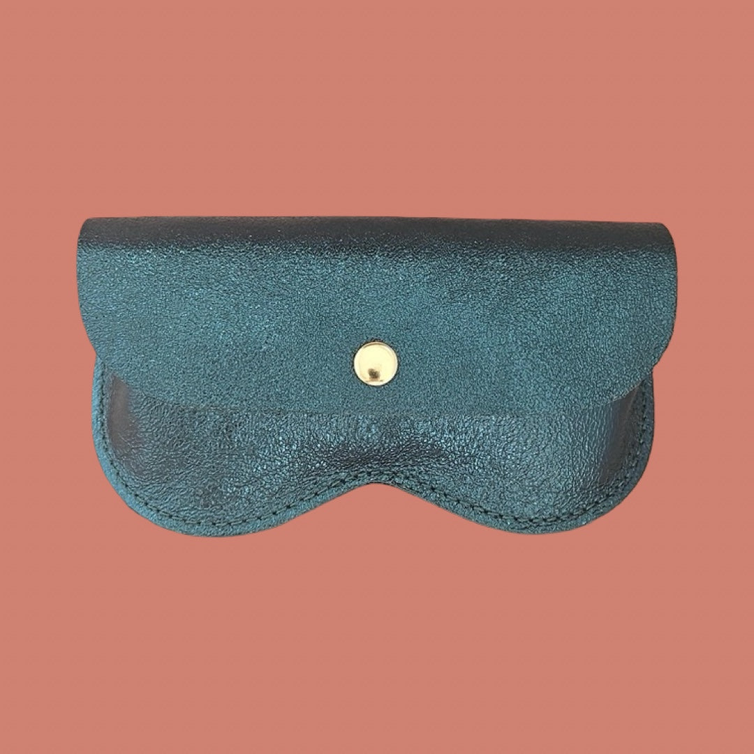 A textured metallic teal blue leather pouch with a curved bottom and a small gold snap button, shown against a solid terracotta background.