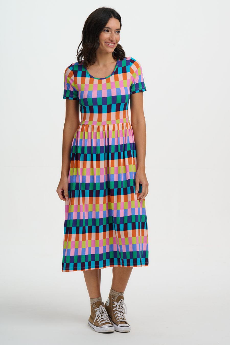 Woman wearing a colorful checkered dress on a white background