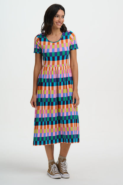 Woman wearing a colorful checkered dress on a white background