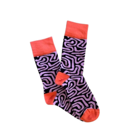 A pair of Afropop socks with a purple and navy pattern and orange accents on a white background