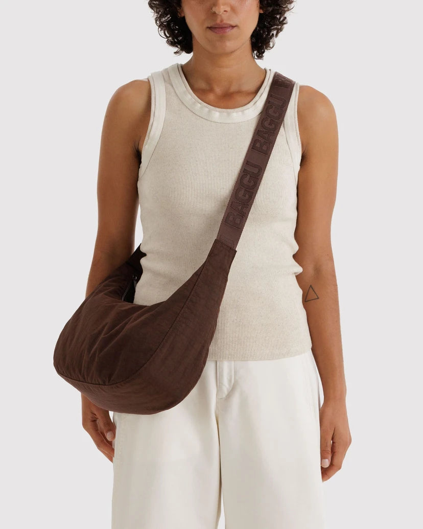 Woman carrying a brown shoulder bag on a white background