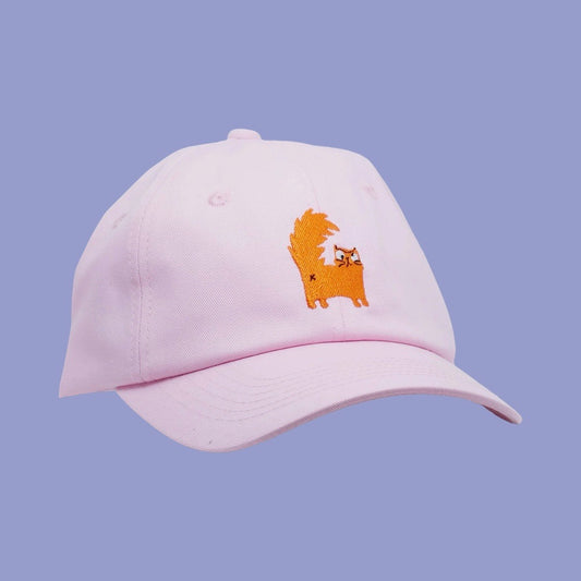 Pink cap with a cat design on a light purple background