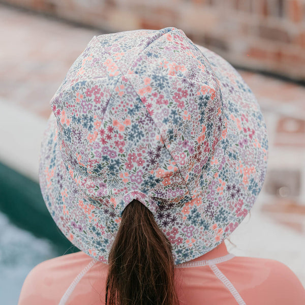 Back view of Bedhead Blossom Swim Bucket Hat worn by a young model with their ponytail through the hat