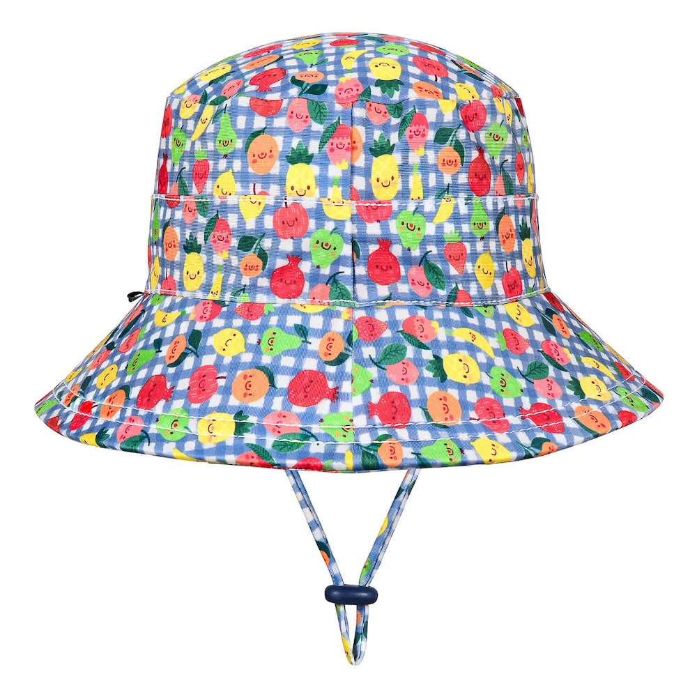 A children's bucket hat with a blue and white gingham pattern and a colourful print of smiling cartoon fruits, including pineapples, strawberries and oranges. It features an adjustable chin strap with a dark blue toggle.