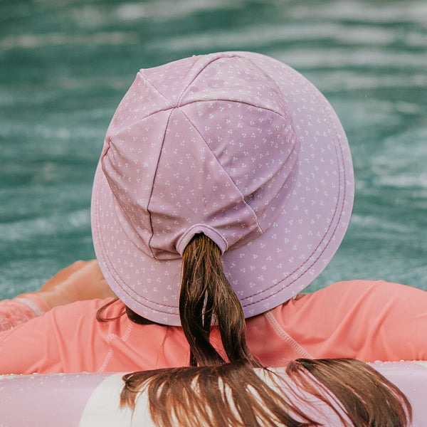 Back virew of Bedhead Lila Swim Bucket Hat worn by young model with their ponytail through the hat