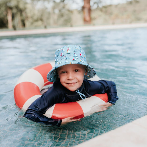 Bedhead Sails Swim Bucket Hat worn by a young model in a swimming pool