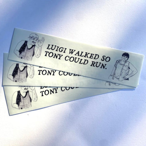 Flat lay of several of Carla Adams Luigi and Tony Bumper Stickers. Text reading "Luigi walked so Tony could run." Two caricatures are positioned on the left and right of the text.
