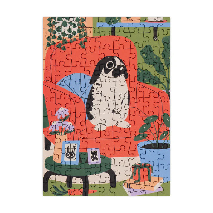 Jigsaw puzzle with a lop-eared bunny on a chair design, partially completed.