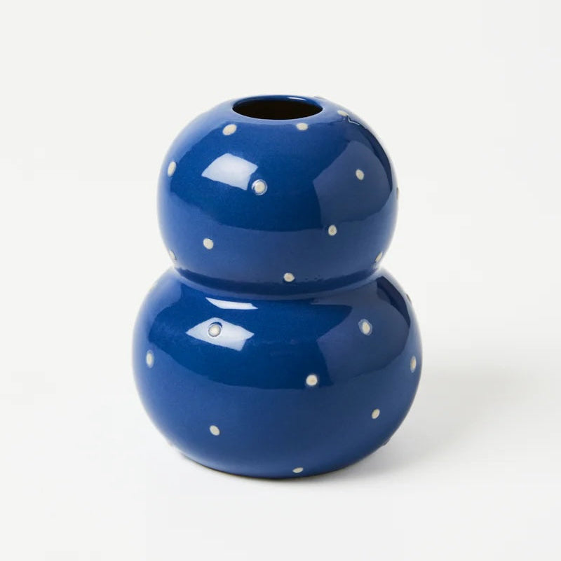 Blue ceramic vase with white polka dots on a white background