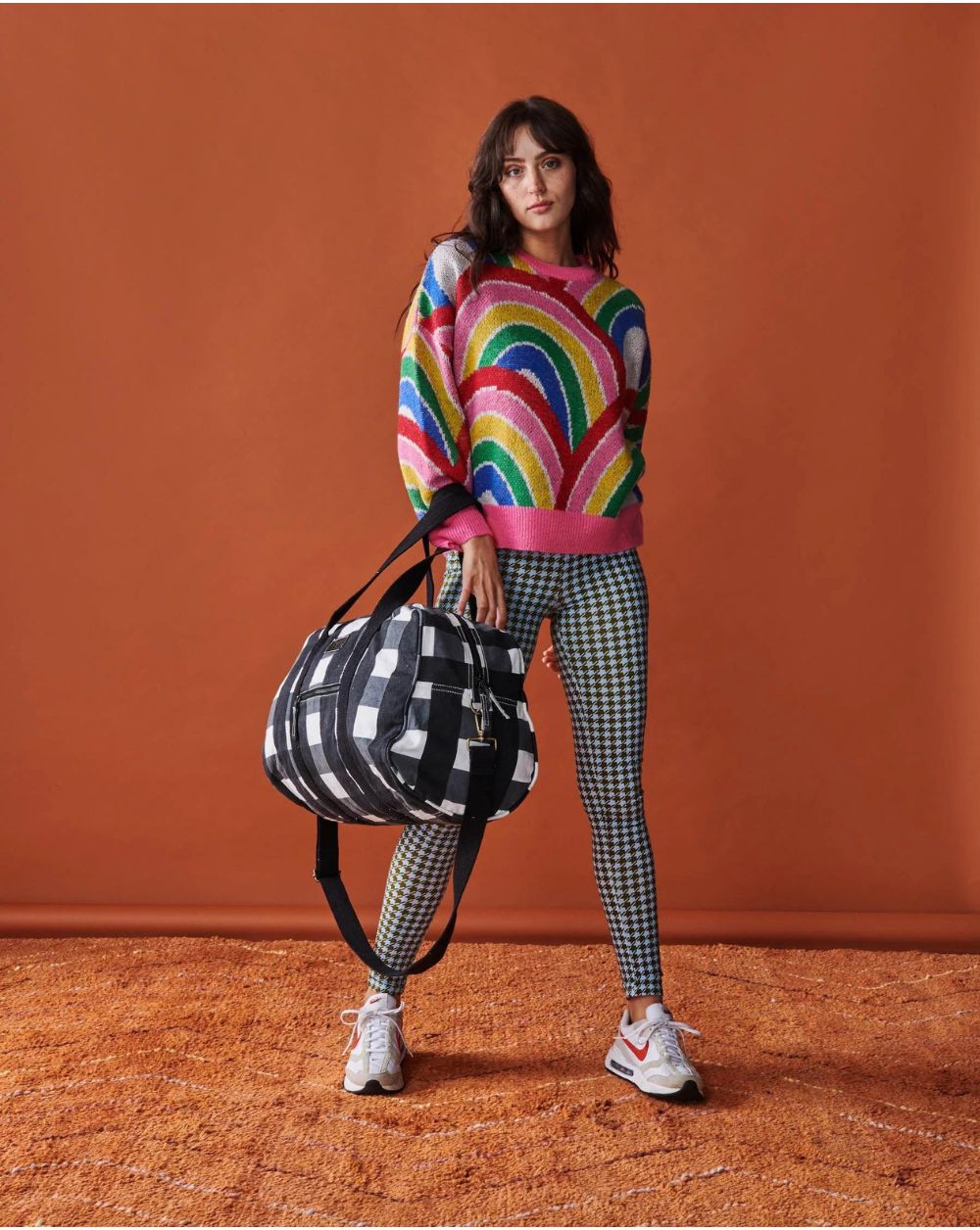 Model is carrying Kip & Co Black & White Gingham Duffle Bag on her arm.