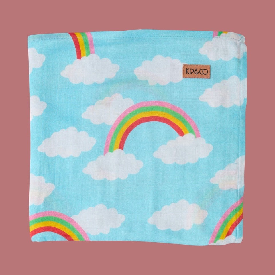 Kip & Co Cloudy Dayz Bamboo Baby Swaddle - Children's blanket with rainbow and cloud pattern on a pink background