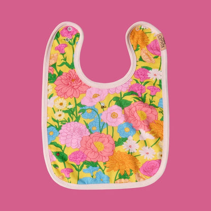 Kip & Co Follow the Sun Yellow Bib
- A floral-patterned bib featuring flowers with stems and a tiny ladybug and bee, on a pink background