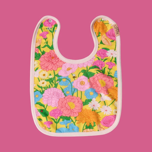 Kip & Co Follow the Sun Yellow Bib
- A floral-patterned bib featuring flowers with stems and a tiny ladybug and bee, on a pink background