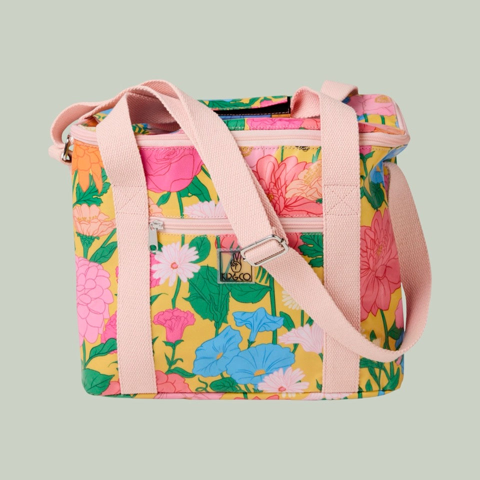 Floral patterned bag with pink straps on a light green background