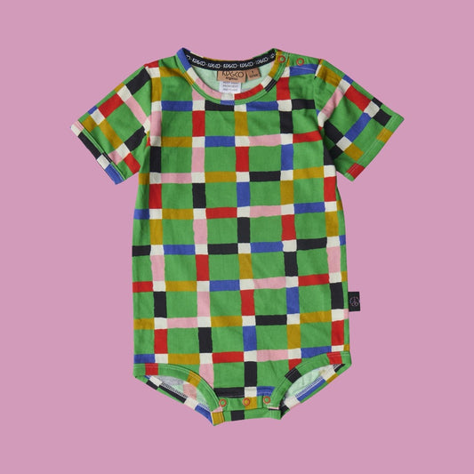 Kip & Co Jolly Tartan Short Sleeve Romper. Colourful checkered baby onesie on a pink background
