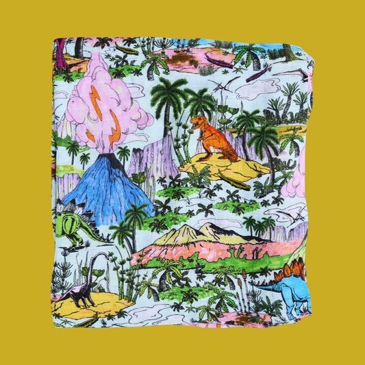Colorful fabric with dinosaur and jungle pattern on a yellow background