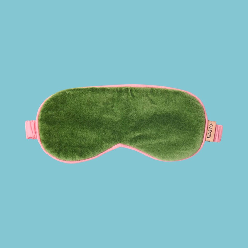 Kip & Co Moss Velvet Eye Mask - Green sleep mask with pink straps on a blue background