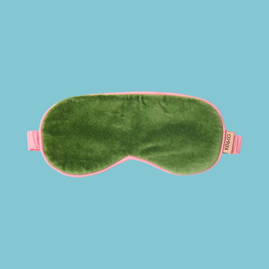 Kip & Co Moss Velvet Eye Mask - Green sleep mask with pink straps on a blue background