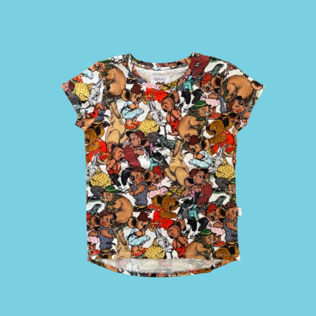 A short-sleeve crewneck t-shirt featuring an all-over dense cartoon illustration print of various Australian characters from the Blinky Bill series, set against a solid light blue background.