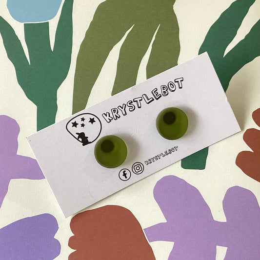 Olive green earrings on a Krystlebot branded card with colourful abstract shapes in the background