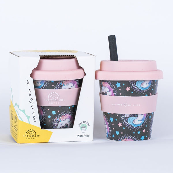 Two Little Cino Social Unicorn Babycino Cups in Pink sitting side by side. One is inside the packaging box, the other has a black coloured straw inserted through the mouthpiece.