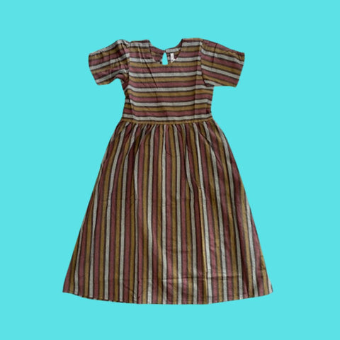 Mata Traders Kavita Stripe Dress. This dress features horizontal stripes across the bodice, and vertical stripes from the waist down. The stripes are in hues of brown and light grey.