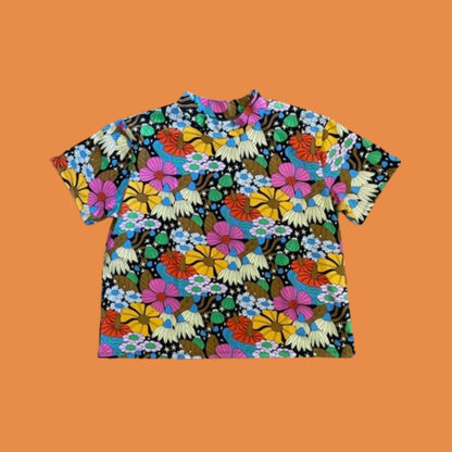 Nooworks Cosmic Floral Mock Neck Top - a bold and colourful floral-patterned shirt on an orange background