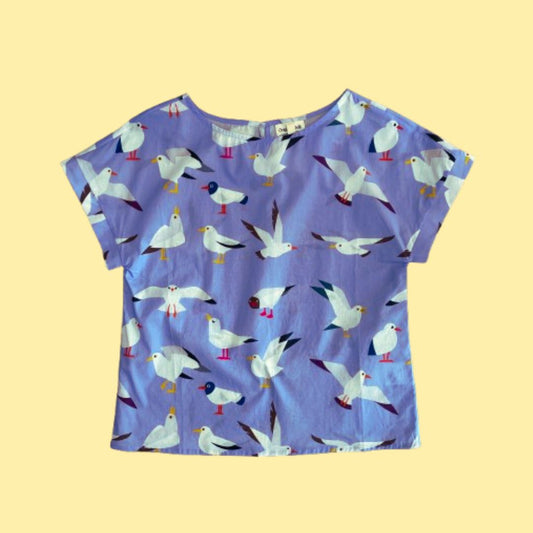 Flat lay of Origami Doll Freya Seagull Top. The top features seagulls in various postures.