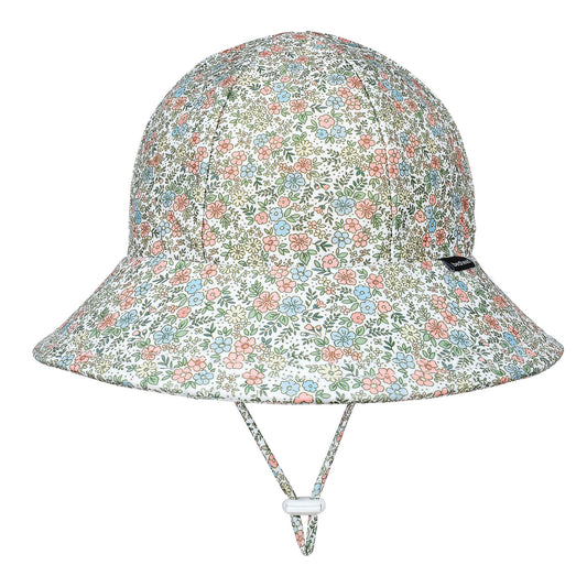 A bucket-style sun hat with a dense multicolor floral print on a white background, featuring a chin strap with a white plastic toggle, shown against a plain white background.