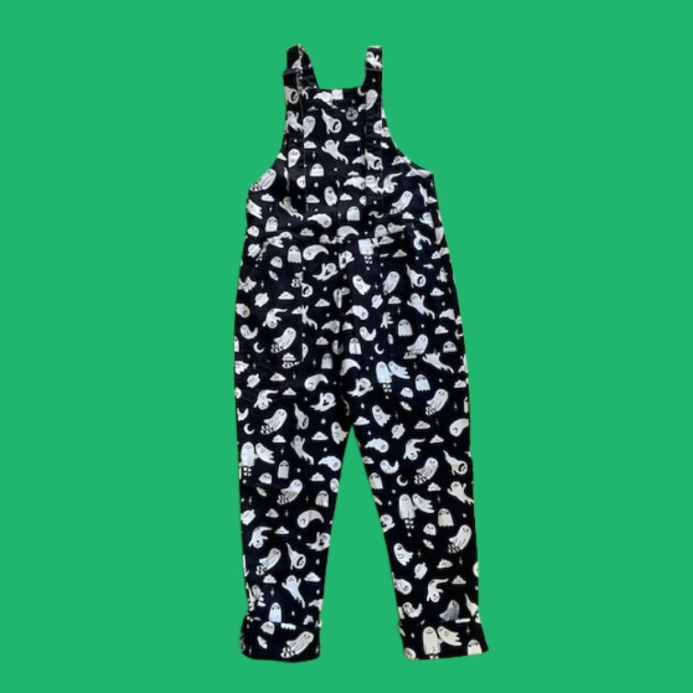 Black overalls with white ghost patterns on a green background