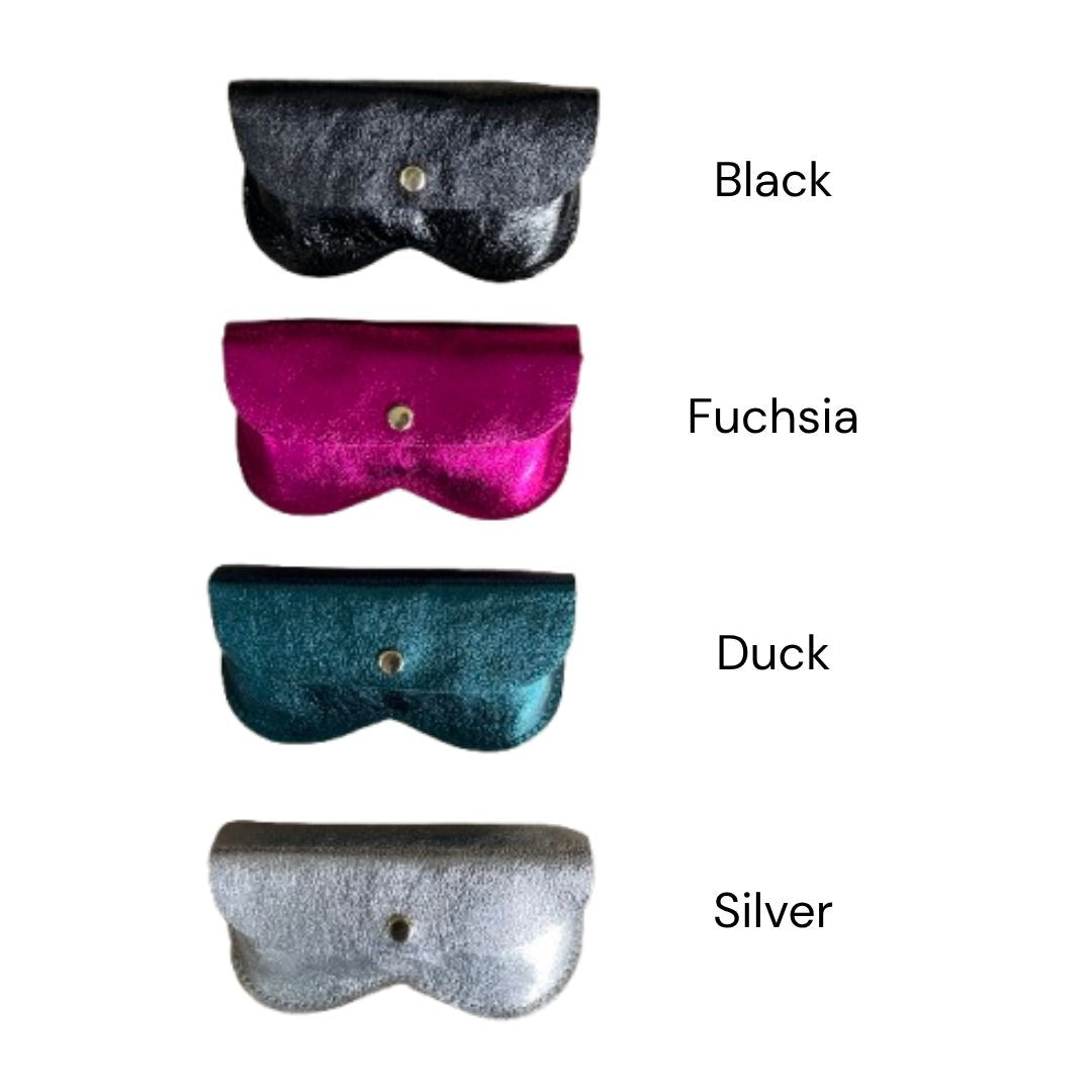 Four metallic leather glasses cases in black, fuchsia, teal, and silver, arranged vertically on a white background with text labels indicating the colour names.