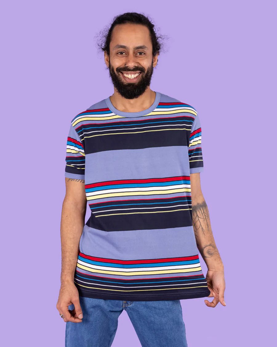 Model is wearing Run and Fly Blue Stripe Tee and smiling at camera.