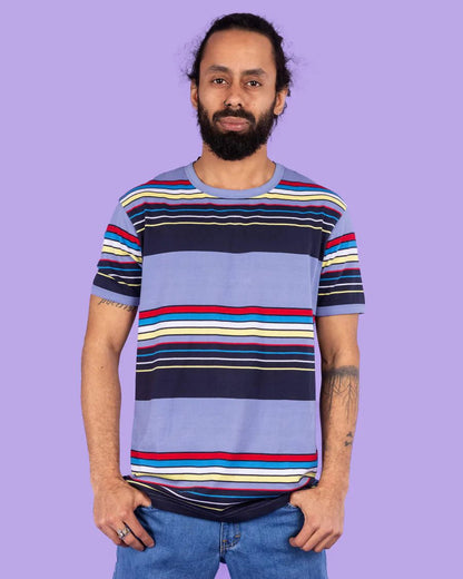 Model is wearing Run and Fly Blue Stripe Tee and smiling at camera.
