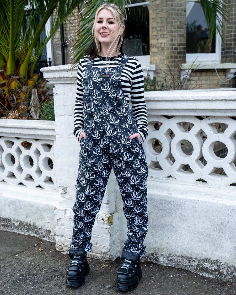 Model is wearing Run and Fly Checkerboard Swallow Twill Dungarees with both hands in the side pockets.