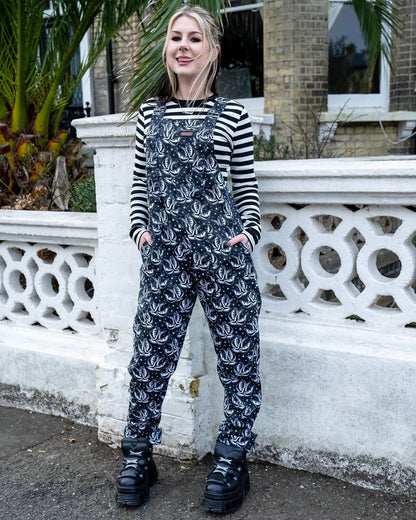Model is wearing Run and Fly Checkerboard Swallow Twill Dungarees with both hands in the side pockets.