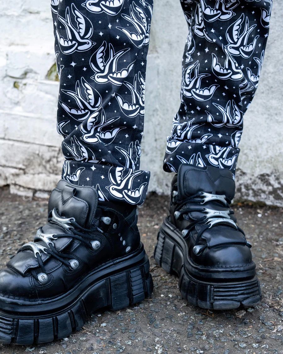 Close up of the bottom of the Run and Fly Checkerboard Swallow Twill Dungarees worn by a model with chunky black shoes.